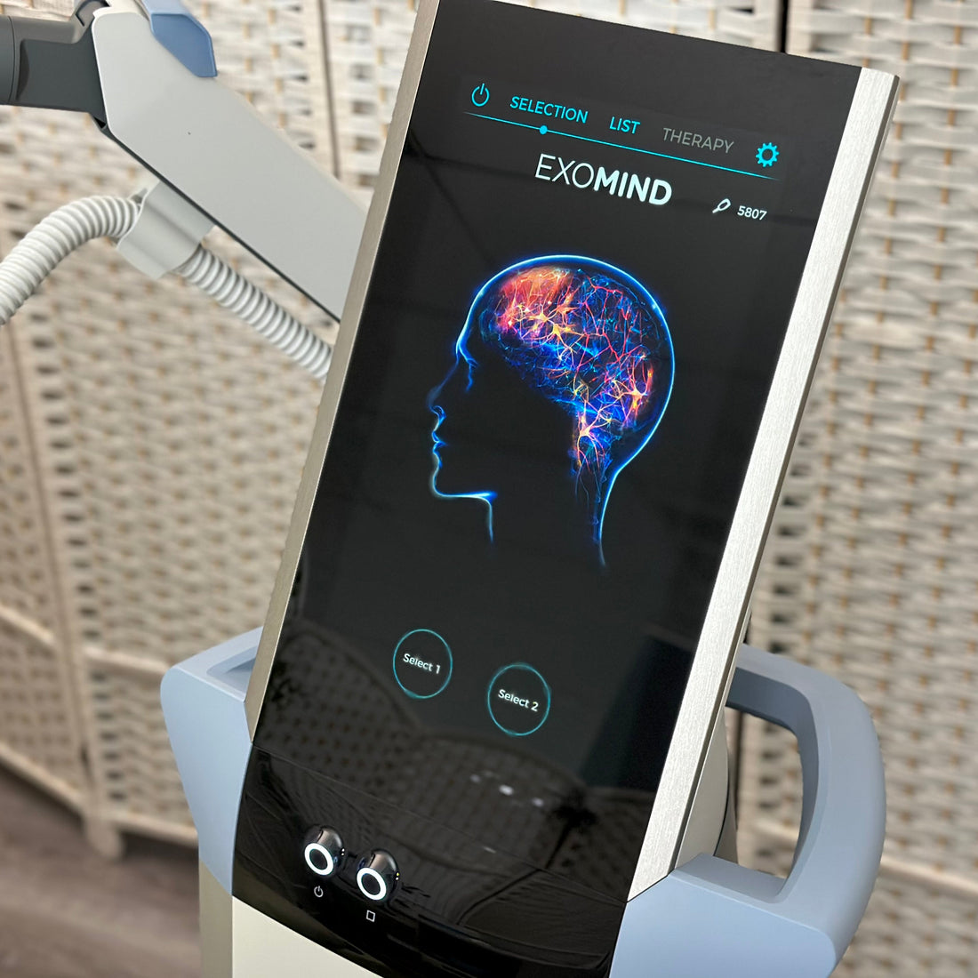 Exomind device with a screen displaying brain imagery on a wicker chair background