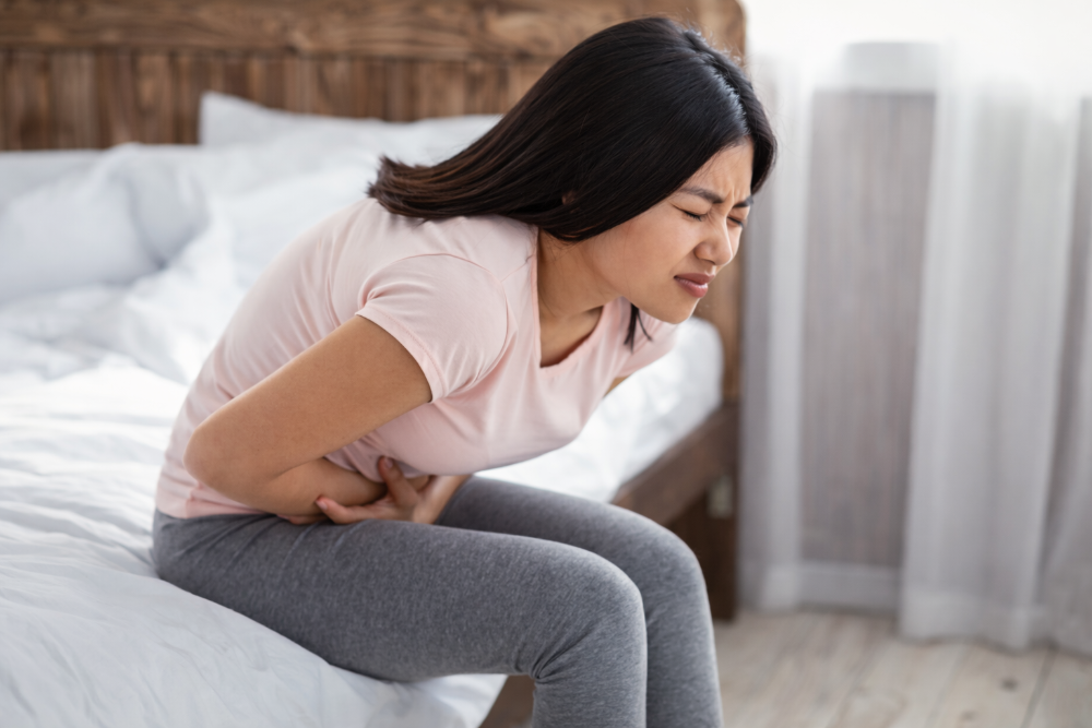 Woman experiencing period pain in bed